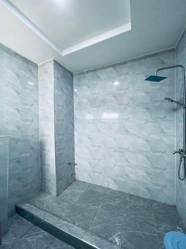 a bathroom with a shower and a tiled wall at Soilsmart haven in Abuja