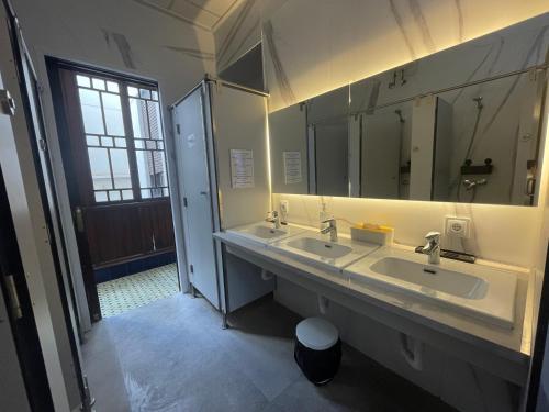 a bathroom with two sinks and a large mirror at The Cathedral Hostel in Murcia
