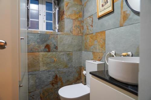 a bathroom with a toilet and a sink at Casas Martinho - O Baloiço in Piódão
