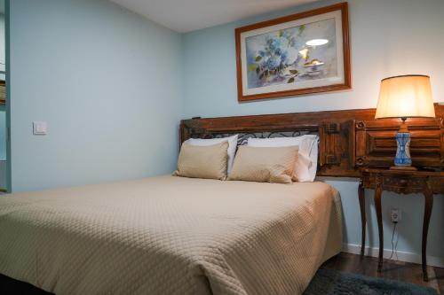a bedroom with a bed with a wooden headboard at Casas Martinho - O Baloiço in Piódão