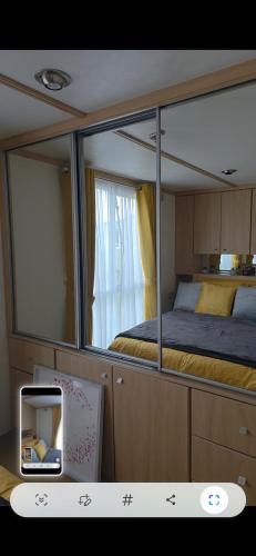 a bedroom with a bed and a large mirror at The Joanack Breeze in Withernsea