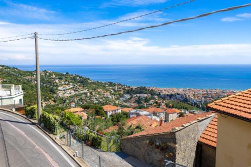 a view of a city with the ocean in the background at Hostdomus - Brezza Marina House in Alassio