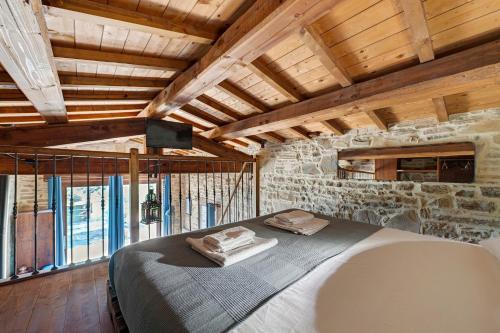 a bedroom with a bed and a stone wall at Nerbone Farm Retreat in Perugia