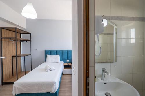 a small bathroom with a bed and a sink at Sunny Hotel in Sarandë
