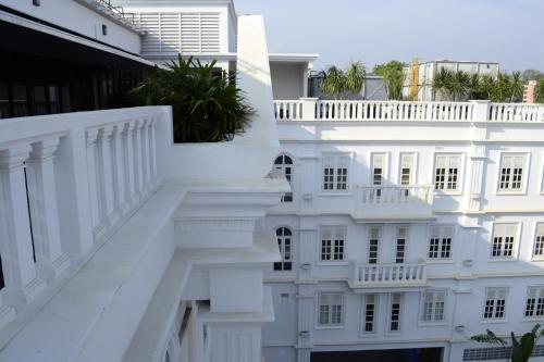 a white building with white railings and a balcony at The Sterling Boutique Hotel Melaka in Melaka