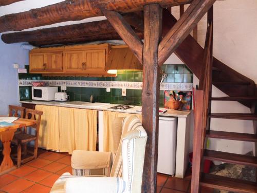 una cocina con armarios de madera y una escalera de caracol en Casas de Zapatierno, en Espierba