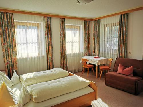 a living room with a bed and a couch and a table at Balthasarhof, Haus in Finkenberg