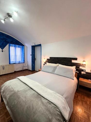 a bedroom with a large white bed in a room at Casa Christa in Castello di Fiemme