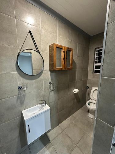 a bathroom with a sink and a mirror and a toilet at Sir Galahad Flatlet 2 in Camelot in Silver Sands