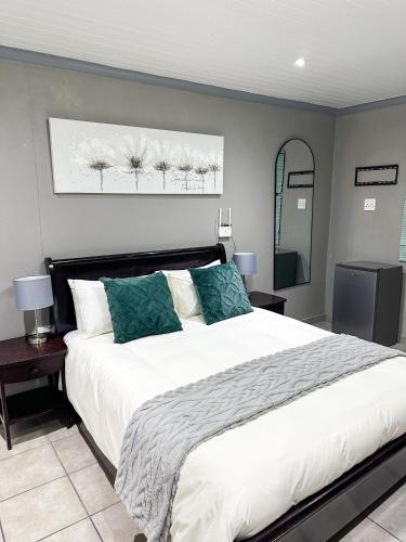 a bedroom with a large white bed and a mirror at Sir Galahad Flatlet 2 in Camelot in Silver Sands