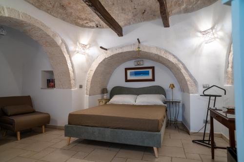 a bedroom with a bed and a chair at I Trulli di Anna in Locorotondo