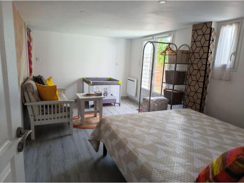 a bedroom with a bed and a living room at Les chambres de Noëlla in LʼAiguillon-sur-Vie