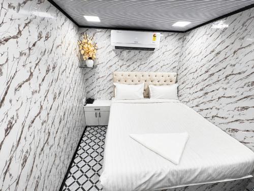 a bedroom with a bed and a stone wall at Cannaught Stays in New Delhi
