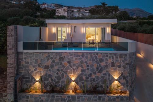 a villa with a swimming pool at night at Terra Falconis in Nipidhitós