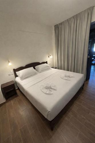 a bedroom with a large bed with white sheets at Psichro Apartments Zeus in Magoulás