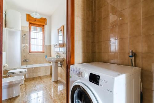 a washing machine in a bathroom with a sink at Annamaria House by BarbarHouse in Marina di Mancaversa