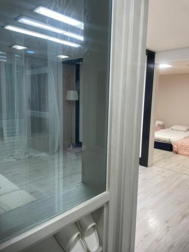 a glass window in a room with a bedroom at 행운외국인여성전용게스트하우스 in Pup'yŏng-yŏk