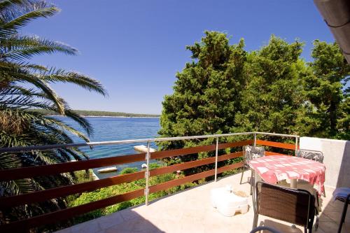 a balcony with a table and a view of the water at Apartments Vila Miranda in Barbat na Rabu