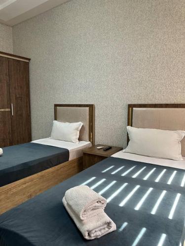 a room with two beds and a towel on the bed at Ситора in Dushanbe