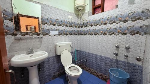 a small bathroom with a toilet and a sink at Backpacker Inn Mcleod in Dharmsāla
