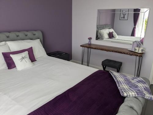 a bedroom with a white bed with a mirror at An Airigh Bed & Breakfast in Kirkhill