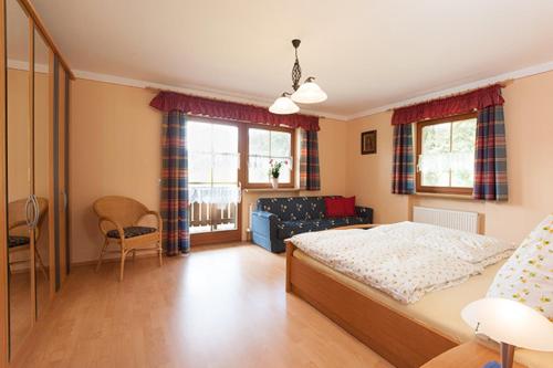 a bedroom with a bed and a couch at Landhaus Almer in Zwiesel