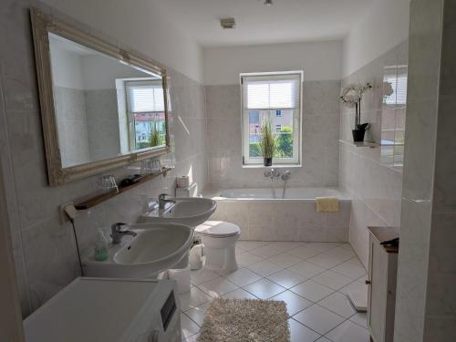 a bathroom with two sinks and a tub and a toilet at Lüsser Landsitz in Bad Belzig