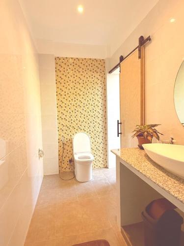 a bathroom with a toilet and a sink at Central 1 Suites in Mambajao