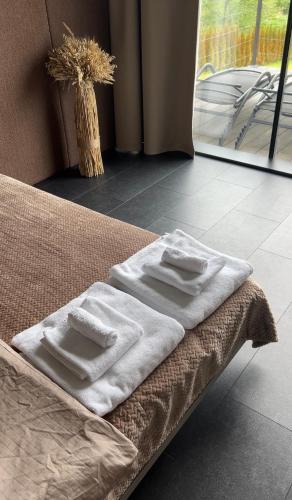 two white towels sitting on a bed in a room at Neboskhyl House in Khorosno