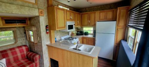 a small kitchen with a sink and a refrigerator at Le Refuge du Navigateur in Tadoussac