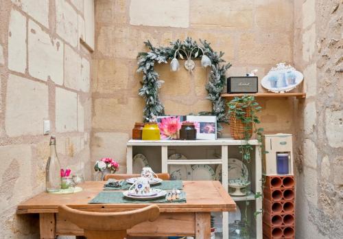 a table and a shelf with dishes on it at B&B Le Miroir aux Fées Bordeaux in Bordeaux