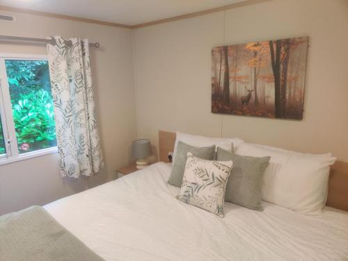a bedroom with a bed with white sheets and pillows at Maggie's Garden Retreat in Millom