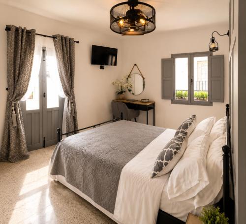 a bedroom with a bed and a mirror and windows at Villa Otivar - Rio Verde in Otívar