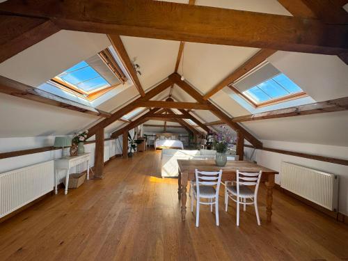 a room with a table and chairs in a room with windows at The Old Stable Block - Flat 2 in Wadebridge