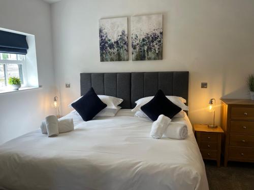 a bedroom with a large white bed with blue pillows at Robins Nest in York