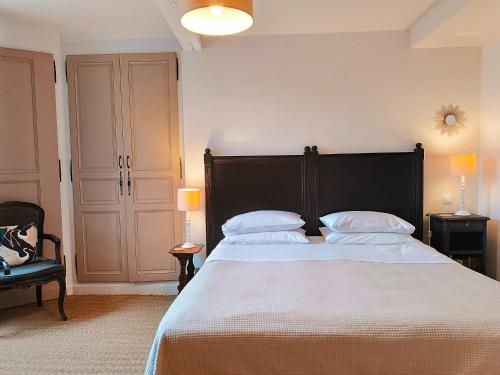 a bedroom with a large bed with white sheets and pillows at Maison Nº 20 in Eymet