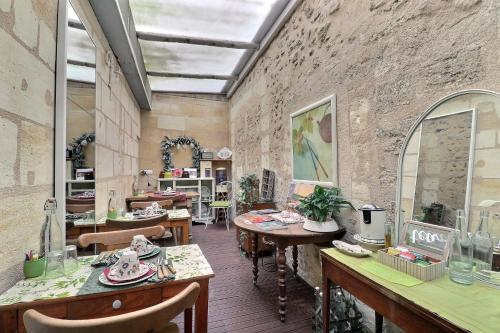a room with tables and chairs and a brick wall at B&B Le Miroir aux Fées Bordeaux in Bordeaux