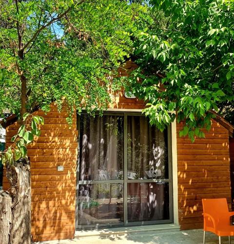 a building with a window and a chair in front of it at TONEDA Seaside Bungalows in Dhërmi