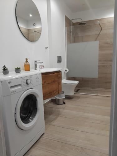 a white washing machine in a bathroom with a toilet at Central House 2 in Ancient Epidauros