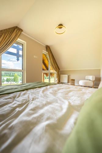 a large room with a large bed with a large window at Osada Wiśniewo in Płótowa
