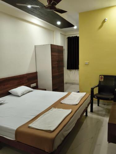 a bedroom with a bed with a chair and a refrigerator at Rutam villa in Shendi