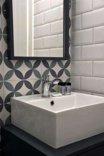 a white sink in a bathroom with a mirror at Samothrakis Michelangelo 401 in Samothraki