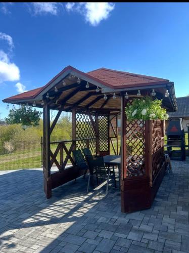 a wooden gazebo with a table and chairs at 3 JASKÓŁKI in Kasina Wielka