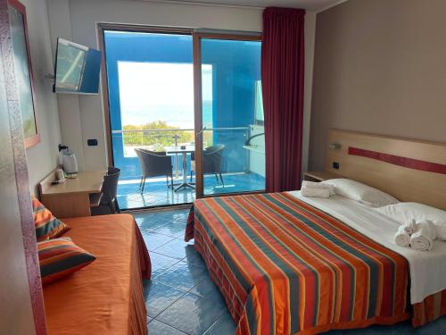ein Hotelzimmer mit Bett und Balkon in der Unterkunft Damavi hotel in San Foca