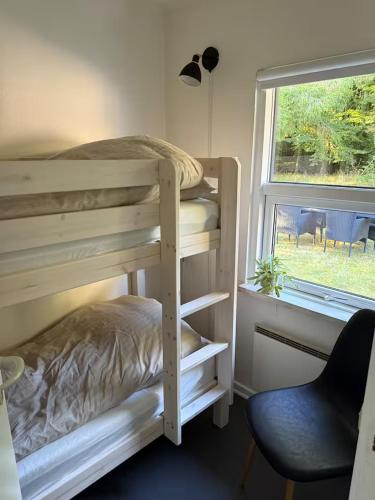 a bedroom with two bunk beds and a window at Sommerhus i Hals in Hals