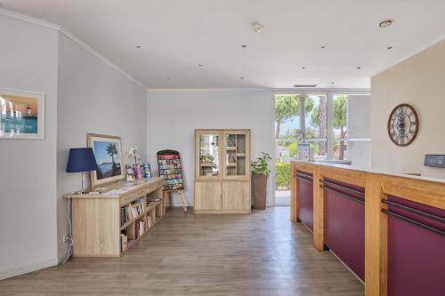 a living room with a counter and a desk and a window at Résidence Odalys Aqualia in Balaruc-les-Bains