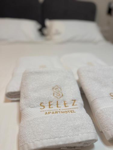 a pile of white towels sitting on a bed at Selez Aparthotel & Residence in Durrës