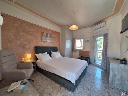 a bedroom with a bed and a couch and a chair at Stella Maris sea front studios in Kanatádhika