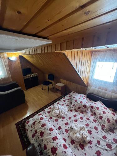 a bedroom with a bed with flowers on it at Cabana Adelin in Dobreşti