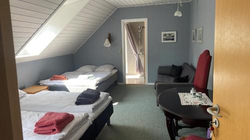a room with two beds and a table and a couch at Hellesbnb in Rømø